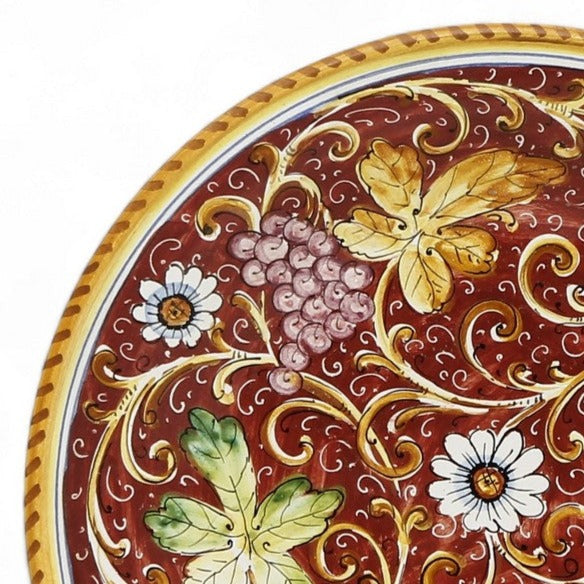 TUSCAN MAJOLICA: Medium wall plate featuring grapes and flowers on a Burgundy Red background (14.5" DIAM)